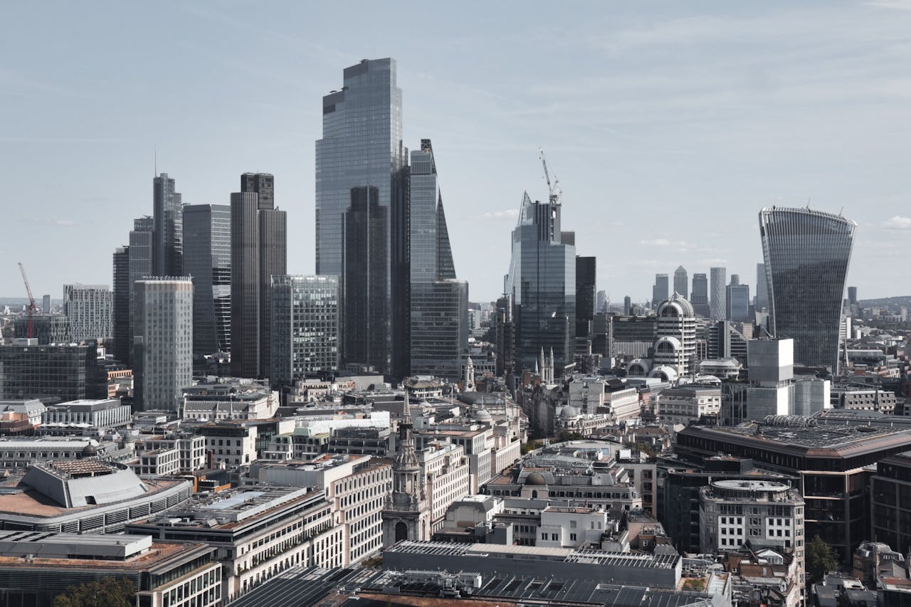 Services Stunning aerial view of London's financial district featuring modern skyscrapers under a clear sky.