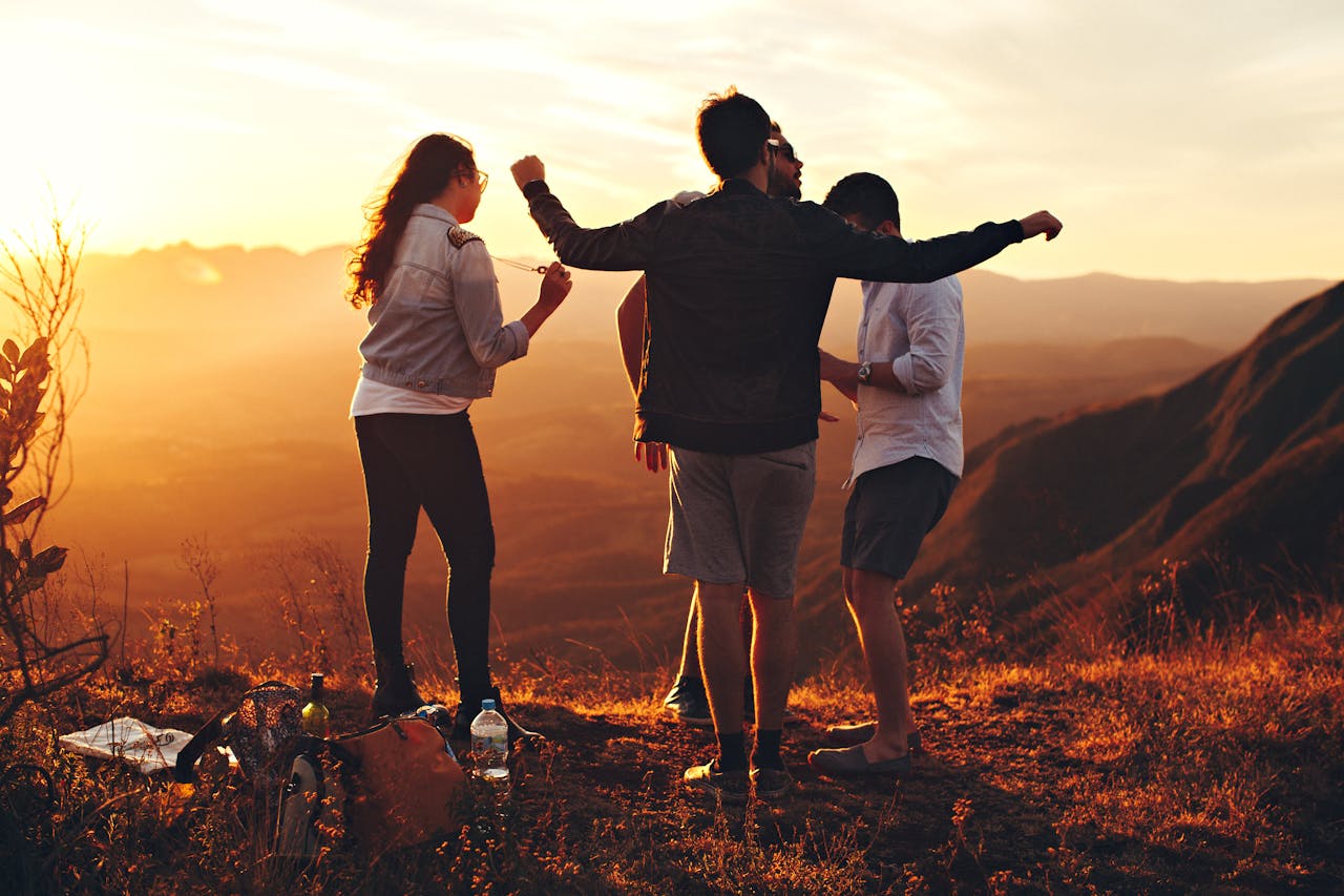 Services Joyful group of young adults enjoying a sunset view in a mountainous landscape in Brazil.