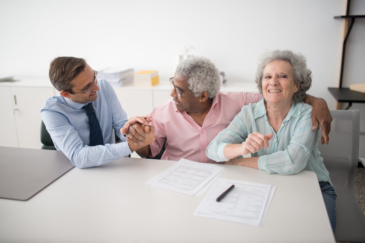 Home Senior couple in office meeting with consultant, discussing financial documents and smiling.
